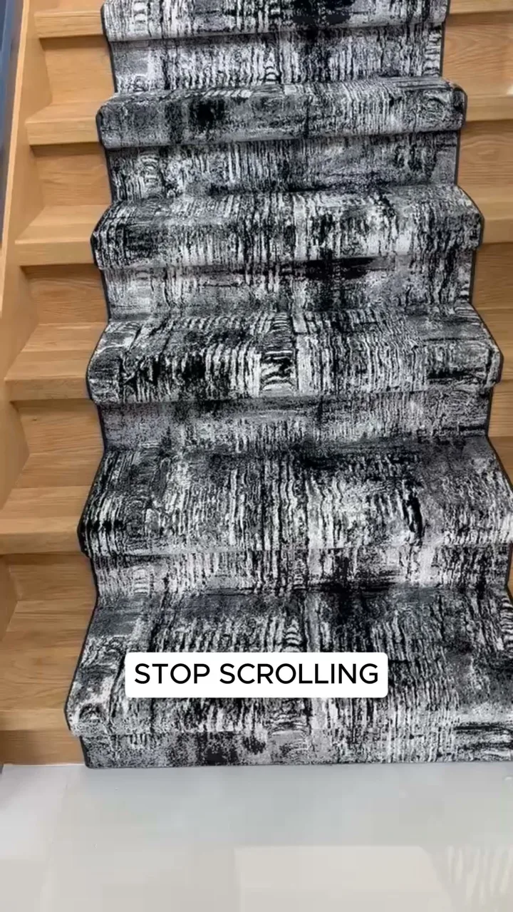 Black and gray patterned carpet runner fitted down a wood staircase